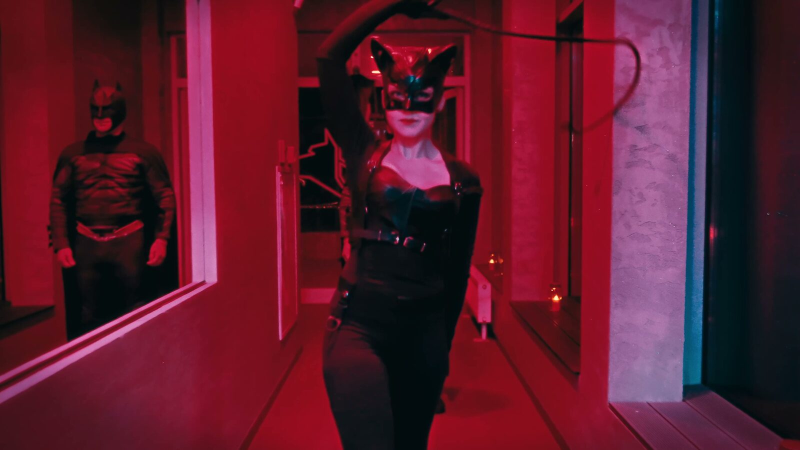 Kobieta w przebraniu Kobiety-Kota idzie korytarzem Hadesu, w tle Batman