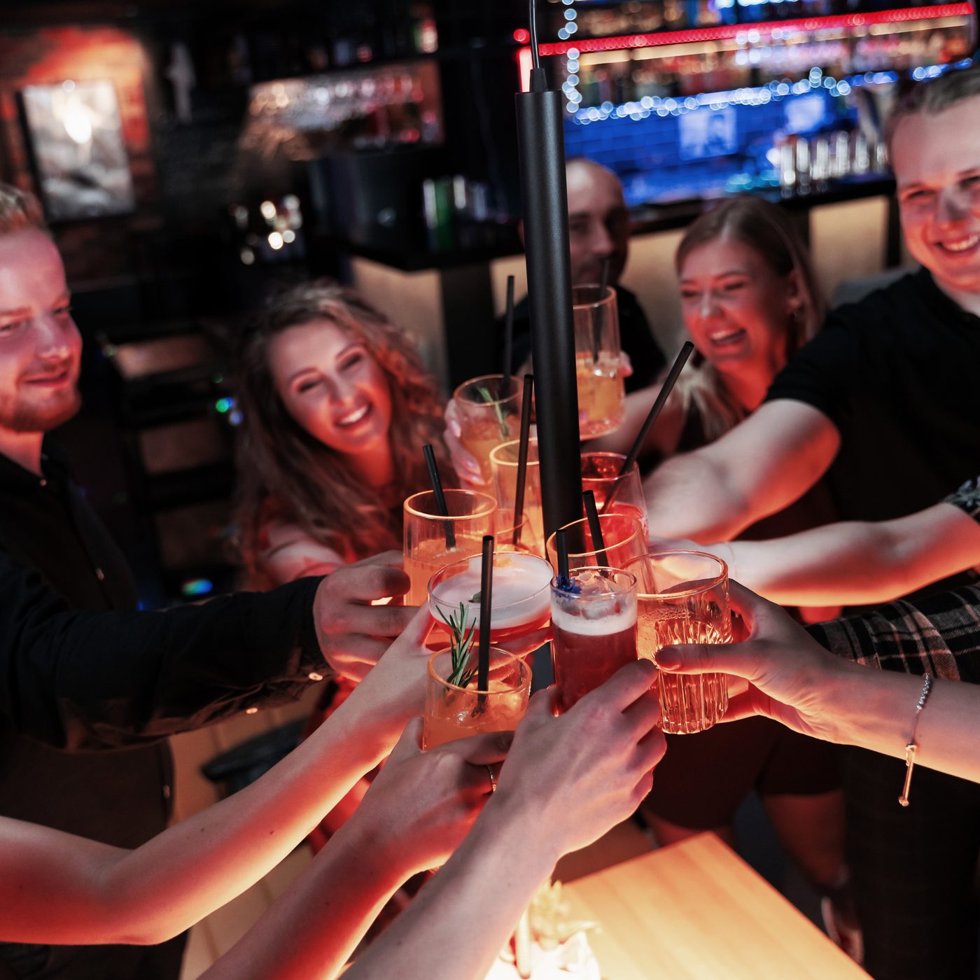 Grupa Gości wznosi wspólny toast kolorowymi drinkami