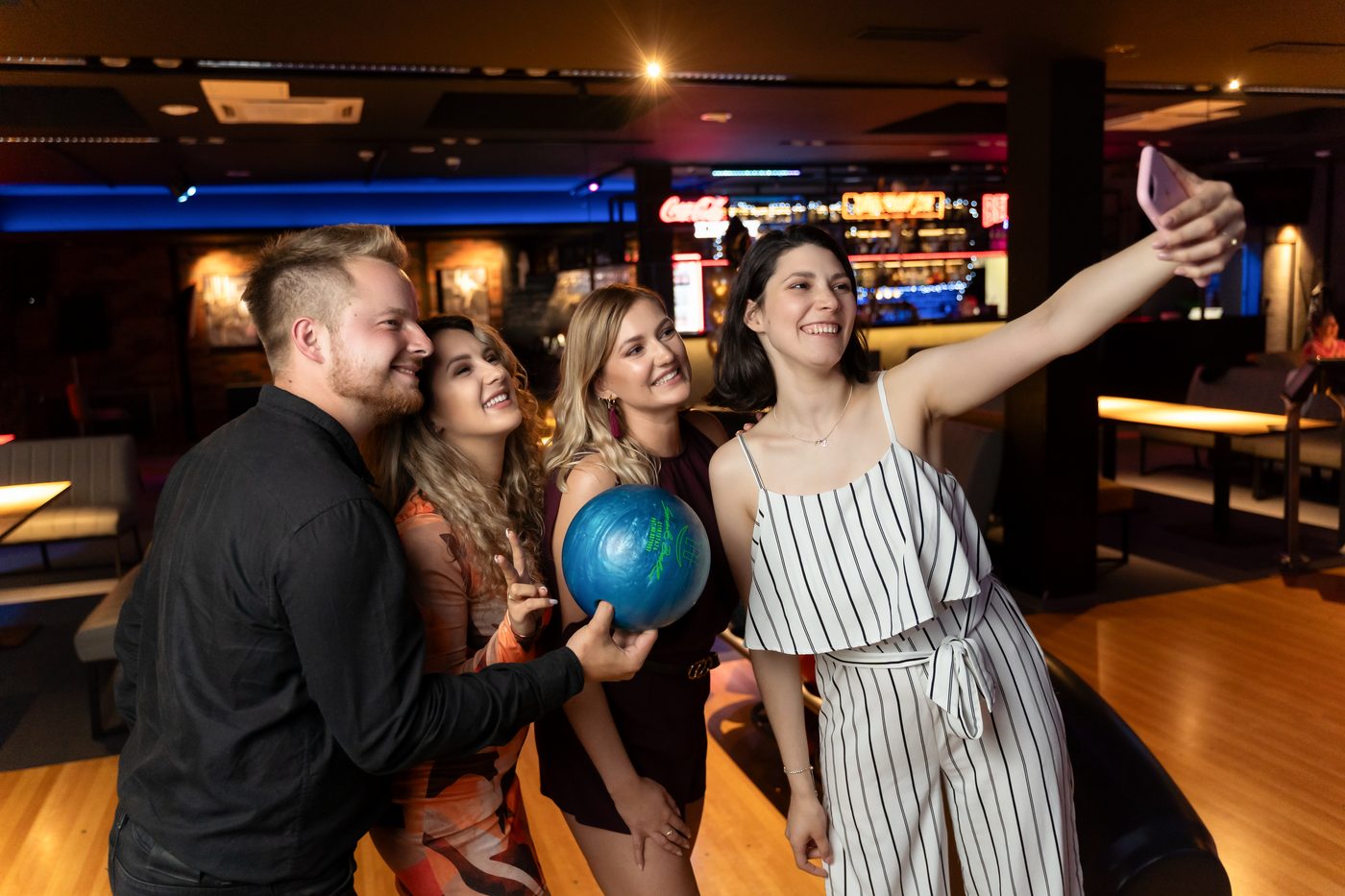 Czwórka znajomych robi selfie z kulą do kręgli