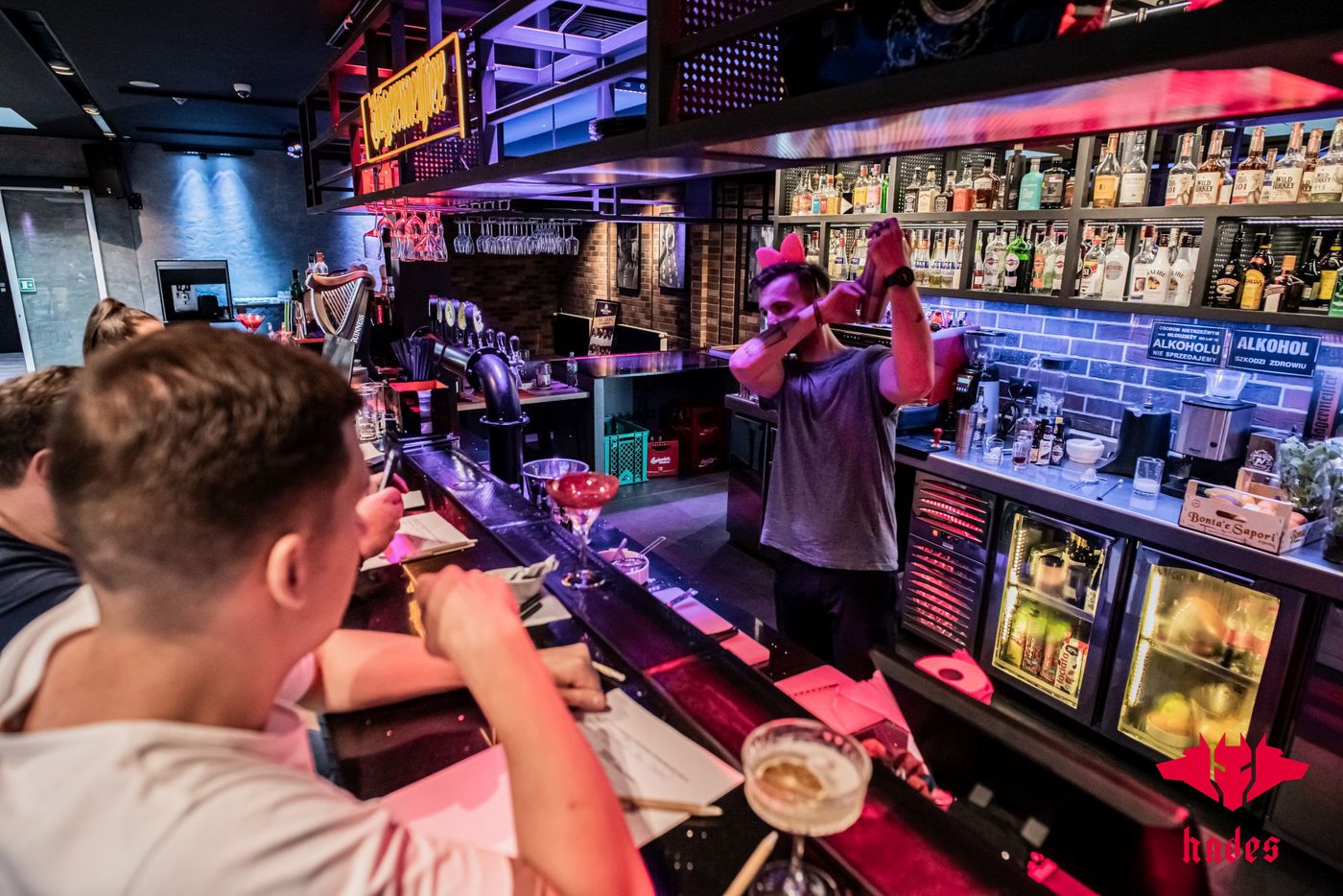 Bar Hadesu z góry: barman i Goście przy kontuarze