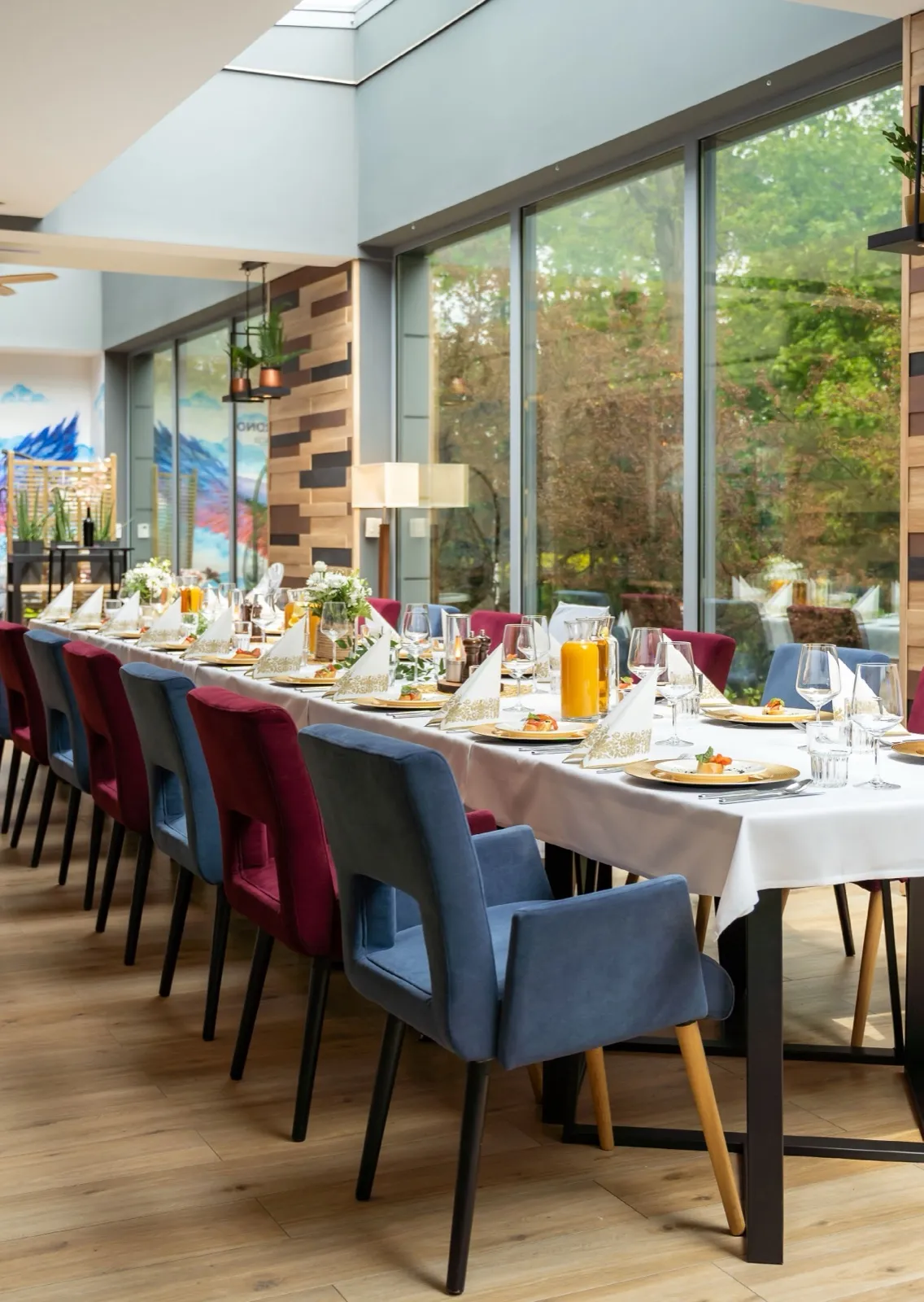 Długi, nakryty stół przy panoramicznych oknach w restauracji Wino i Grono