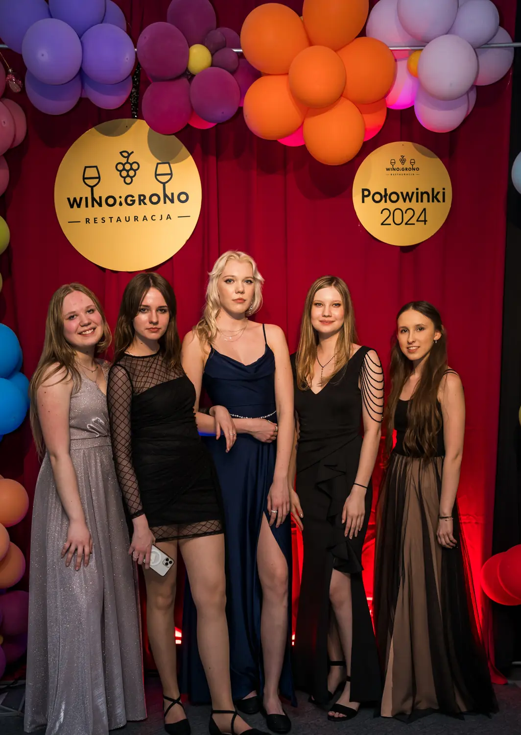Uczennice pozują przy ściance z napisem Połowinki 2024