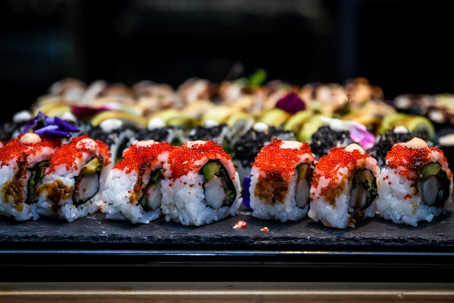 Rolki sushi z czerwoną ikrą i awokado na czarnej płycie
