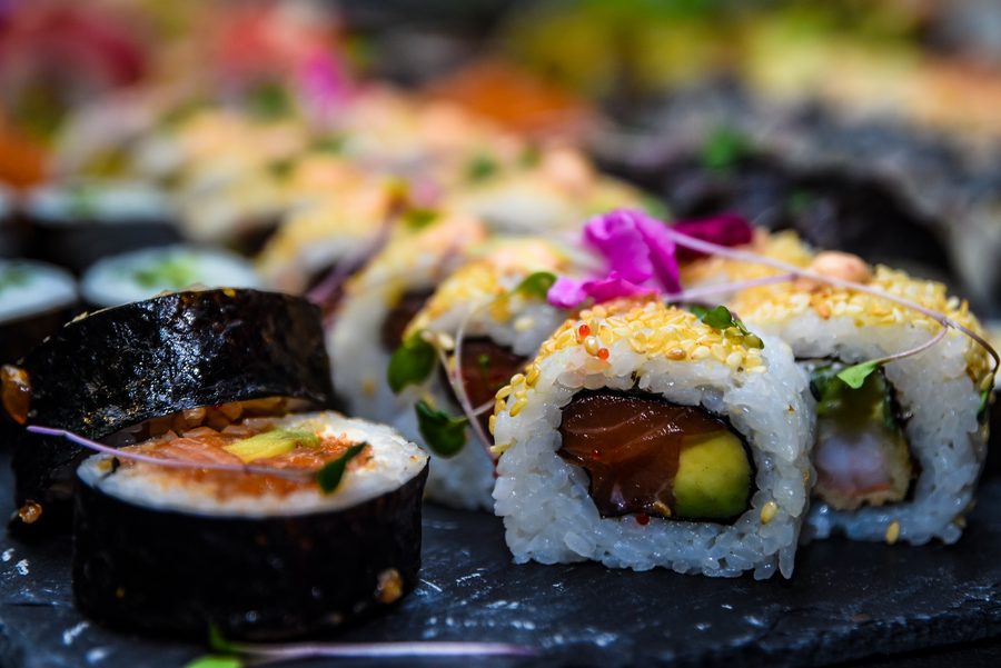 Sushi z łososiem i sezamem ozdobione jadalnymi kwiatami