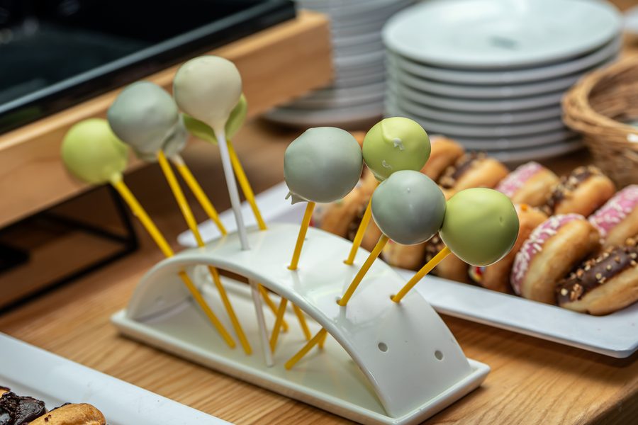 Kolorowe cake popsy i pączki z lukrem na bufecie