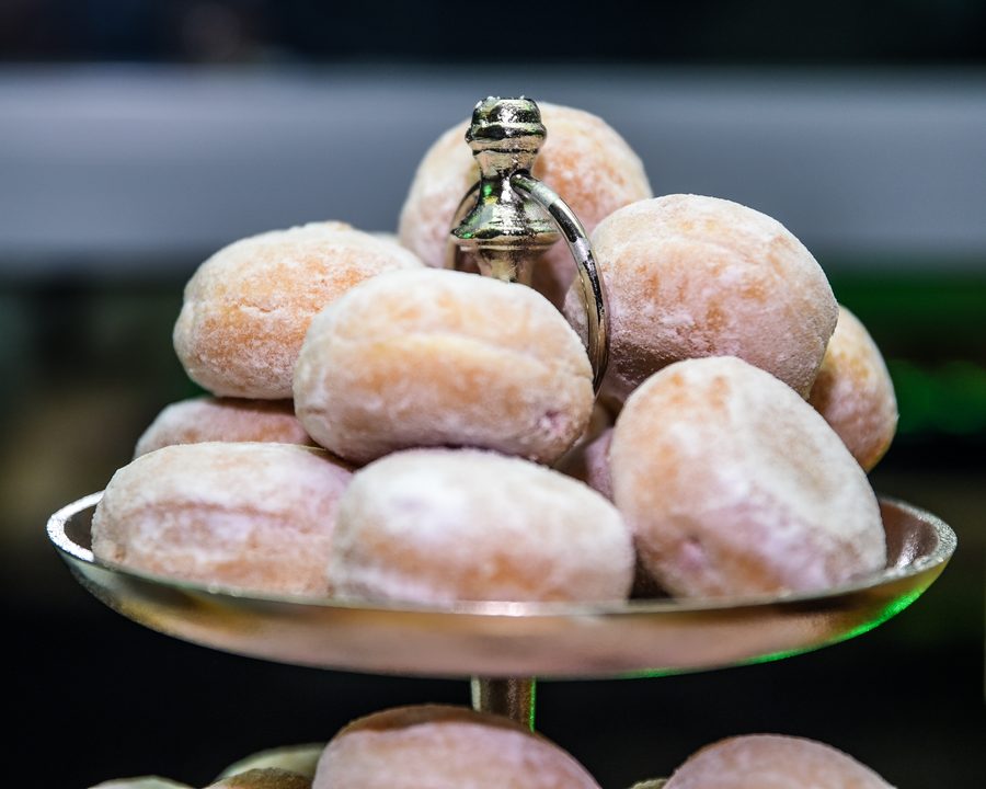 Małe pączki z cukrem pudrem na metalowej paterze