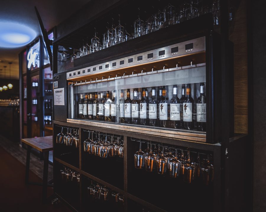 Automat do nalewania wina z rzędem butelek i kieliszkami