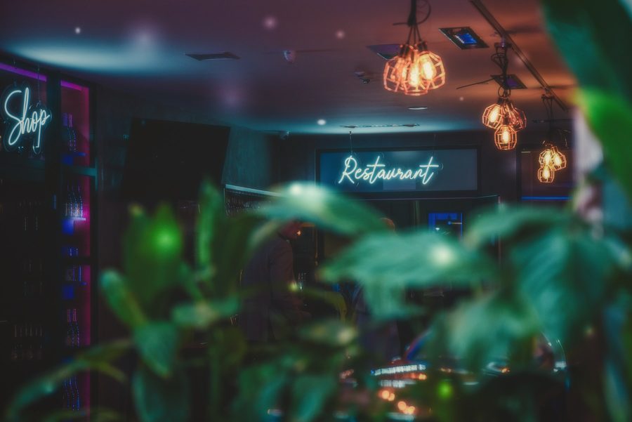 Wnętrze restauracji z neonem Restaurant i zielenią w nocnym świetle